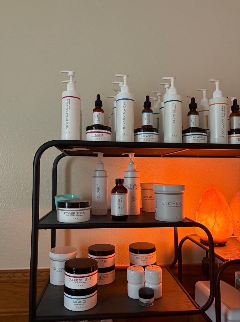 Tuel Professional skincare products arranged on spa shelves, supporting radiant and healthy skin. Displayed are there 5 lines: Calm, Detox, Balance, Moisture & Rescue. Each line is developed for different skin types and facials can be catered toward your skin and your goals. 
